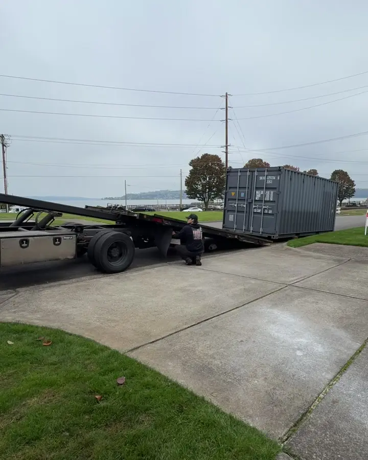 Tilt bed lowered and backed up to the end of a 20 foot shipping container
