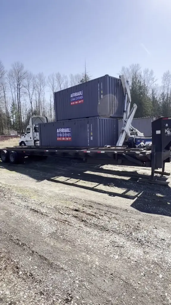 Side loader trailer carrying two shipping containers stacked